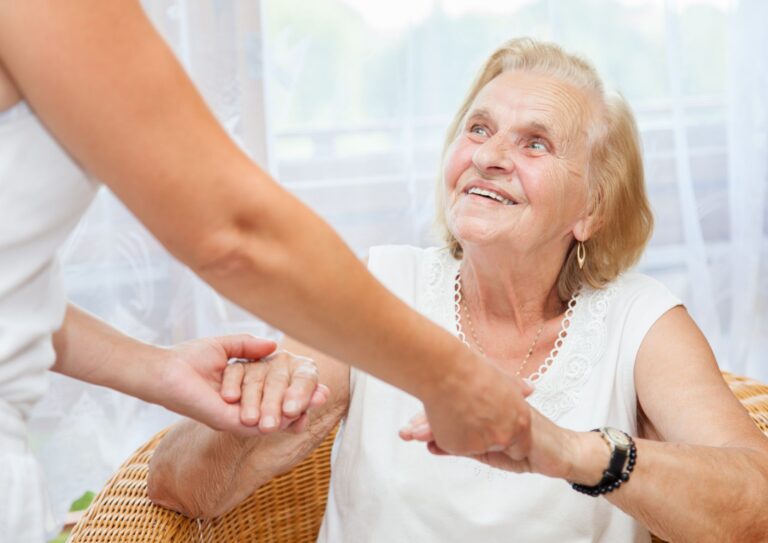 Elderly lady being helped by a healthcare worker.