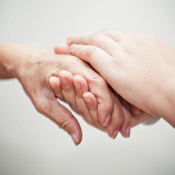 young hands holding elderly hand